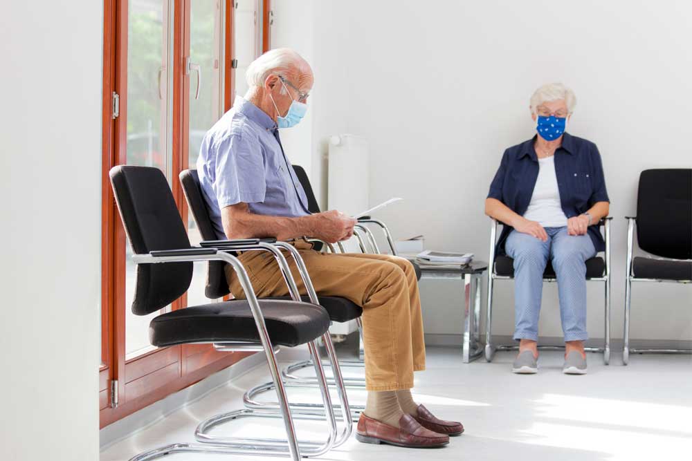 Elderly man wearing face mask in waiting room