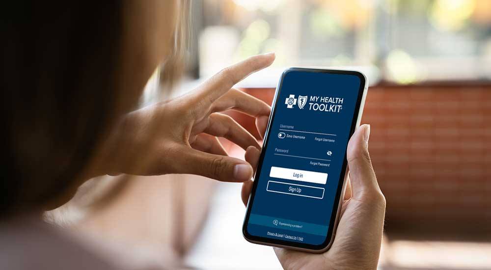 overshoulder view of person's hands holding phone with my health toolkit app open